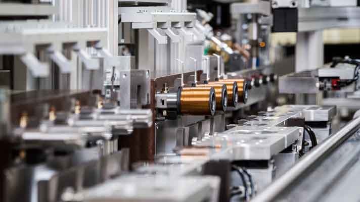 Linea di produzione di bobine per elettrovalvole automobilistiche in fase di installazione.